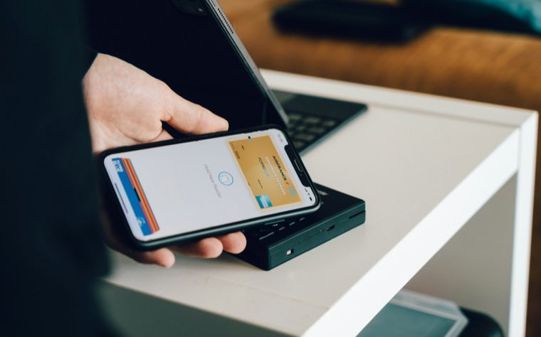Phone and card held over a table