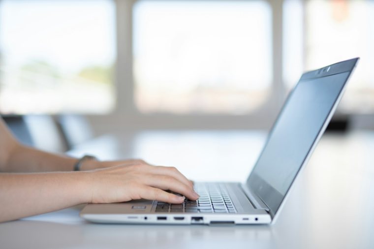 Hands typing on a laptop