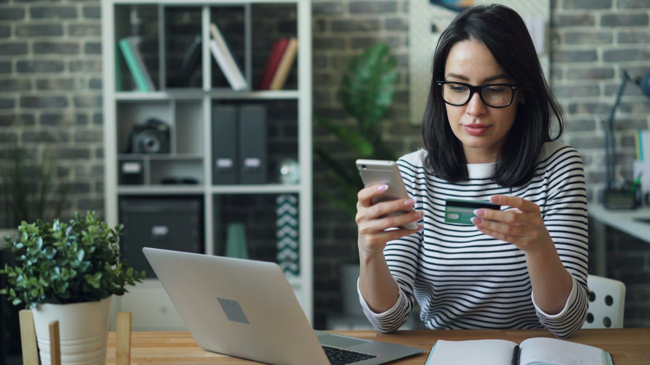 Woman on a phone at a laptop