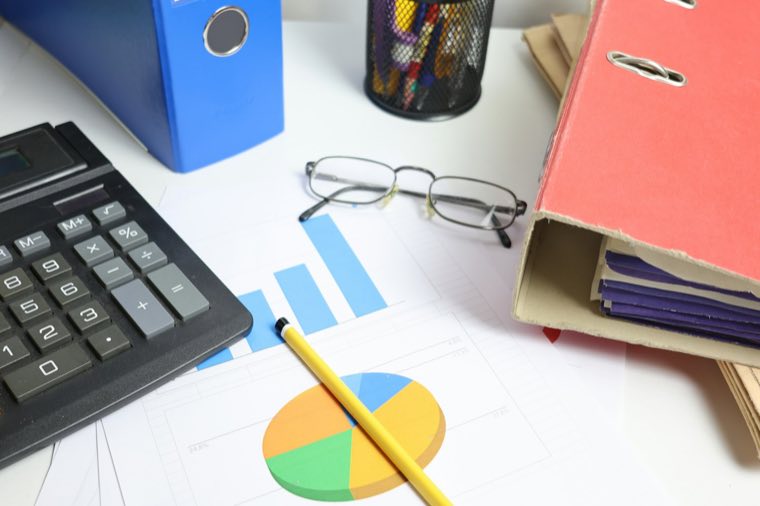 Calculator, folders and glasses on a desk