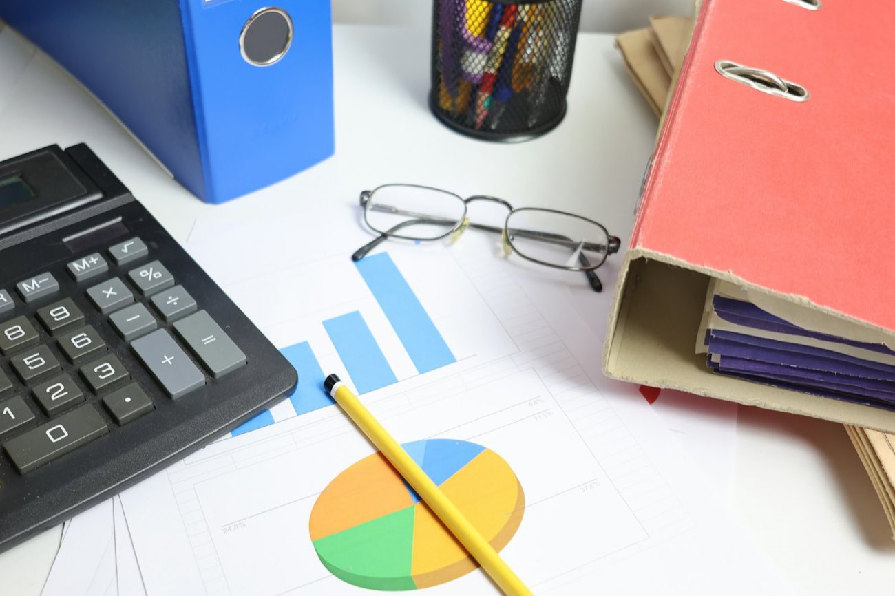 Calculator, folders and glasses on a desk