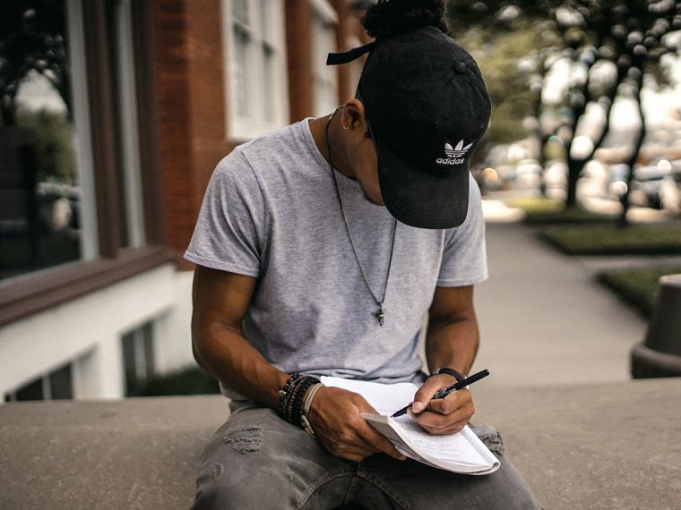 Young man in a cap filling in a form