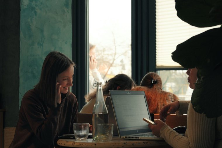 Two women talking at a table with a laptop